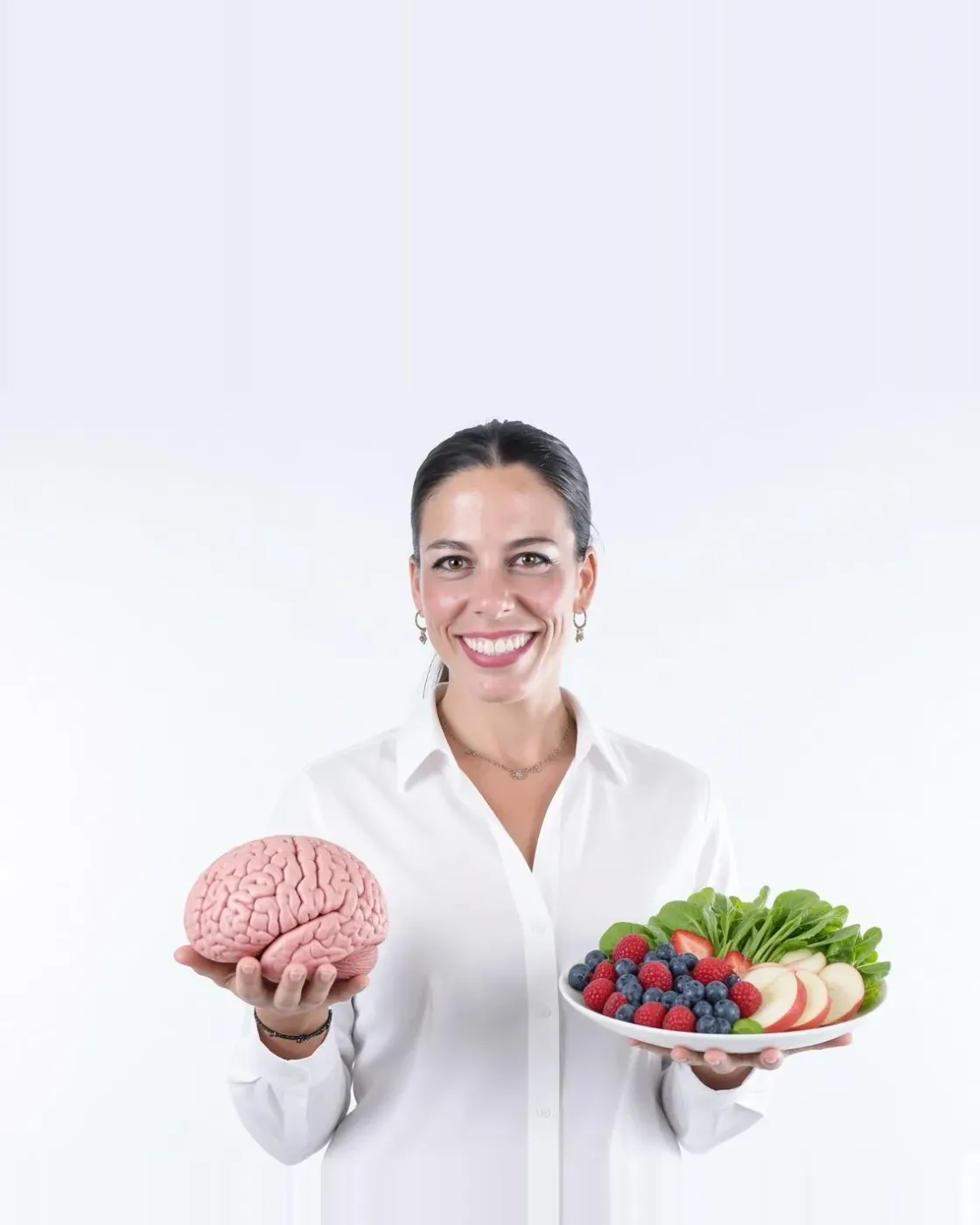 Silvia Suazo sonriendo con un cerebro en una mano y un plato de fruta y verdura en la otra